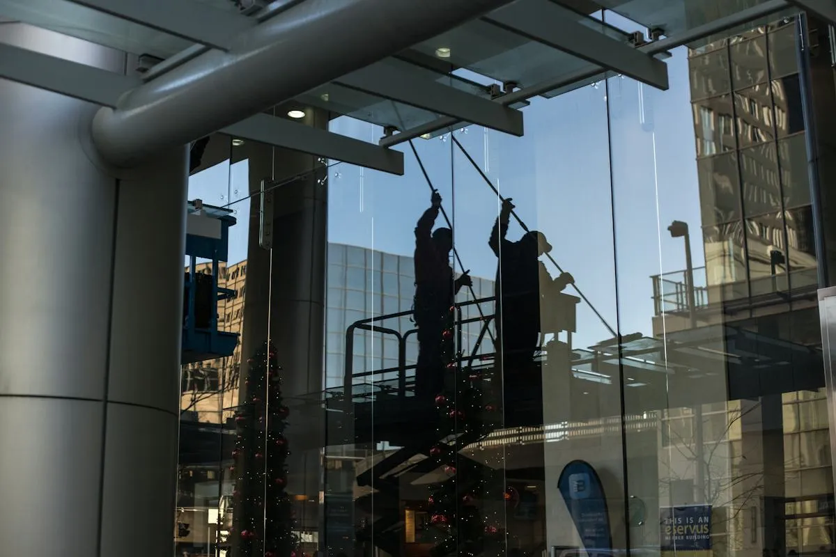 Professional cleaner working on tall office windows