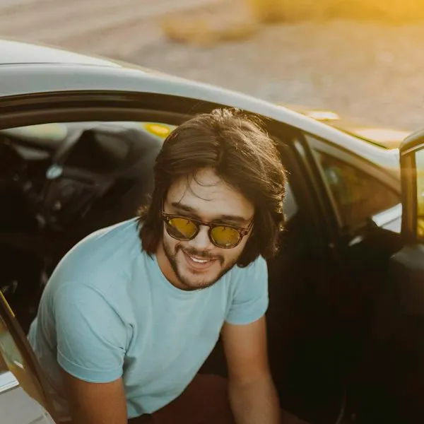Person smiling beside a vehicle
