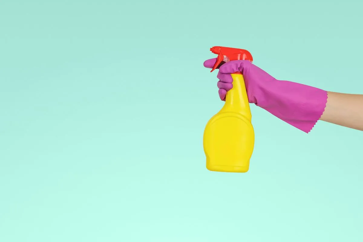 Yellow and pink spray bottles against a pastel background