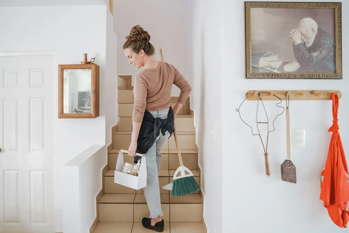 Staff member using cleaning supplies in a living room